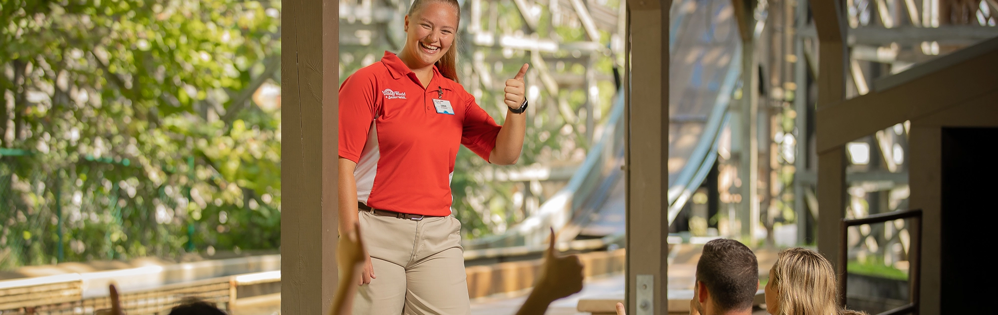 A Team Member trades thumbs-up with Guests riding Frightful Falls.